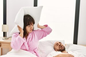 woman frustrated by partner's snoring sleep apnea concept