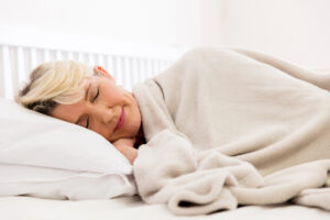 pretty senior woman sleeping on bed