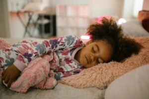 Photo by RDNE Stock project: https://www.pexels.com/photo/child-sleeping-with-toy-10566190/ girl sleeping; pediatric sleep